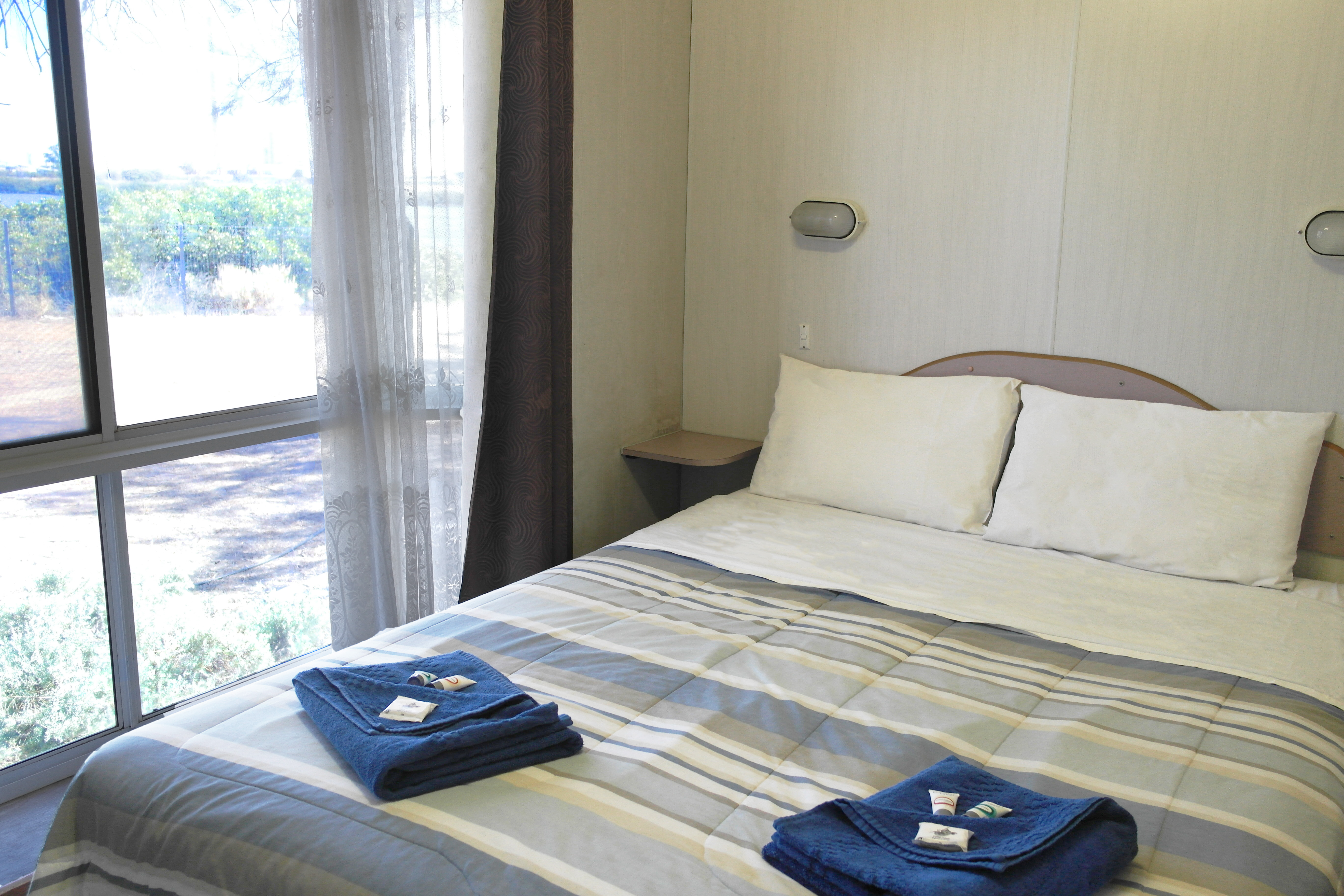 Queen size bed in a cabin at Port Pirie Caravan Park
