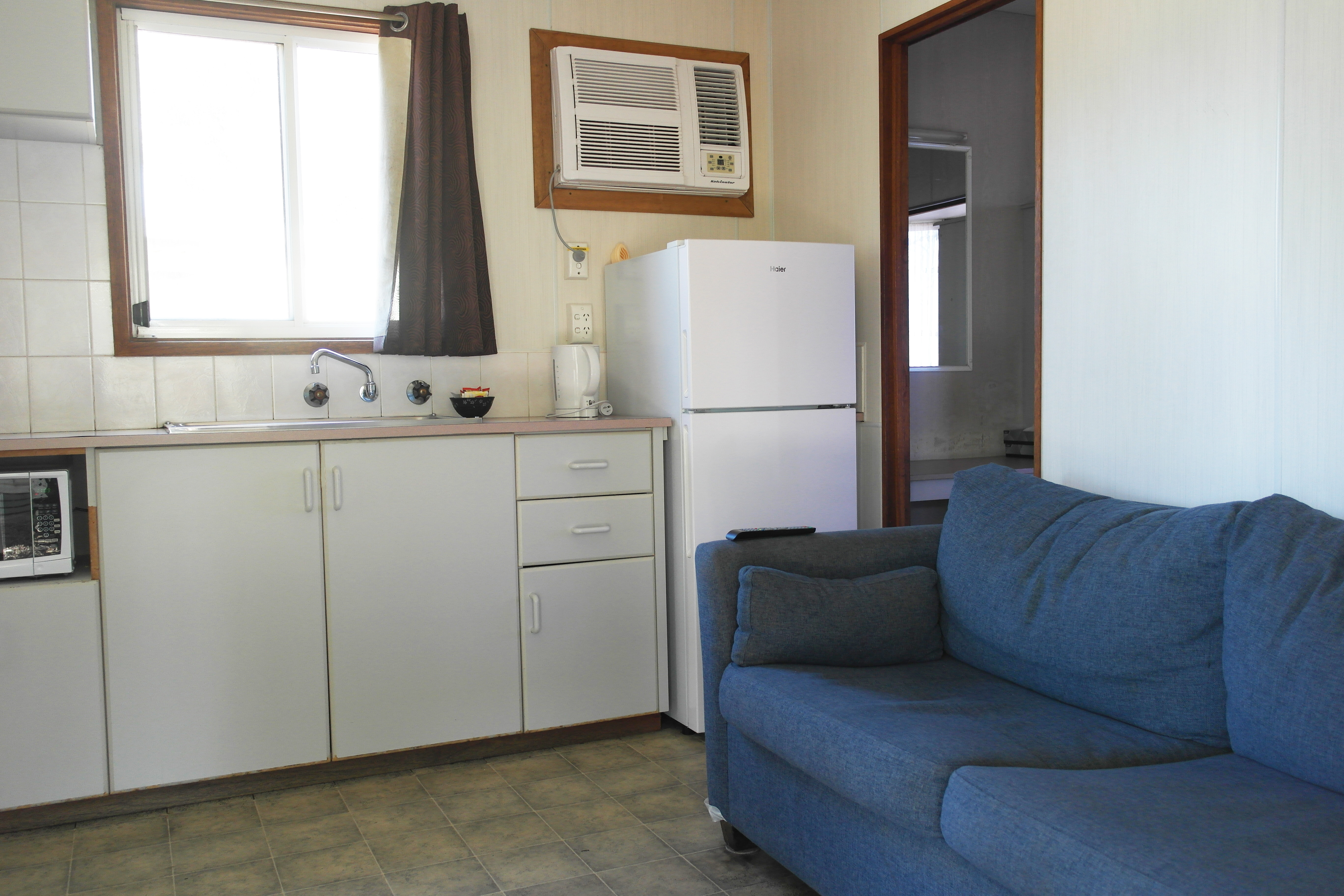 kitchenette and open plan living area in a cabin at Port Pirie Caravan Park